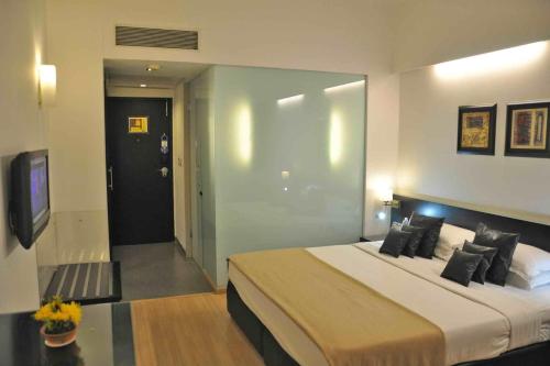 a bedroom with a large bed and a tv at Comfort Inn Sunset in Ahmedabad
