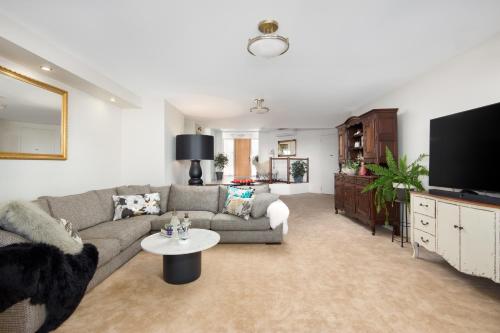 a living room with a couch and a tv at Luna Blu - Luxury B&B in Rhyll