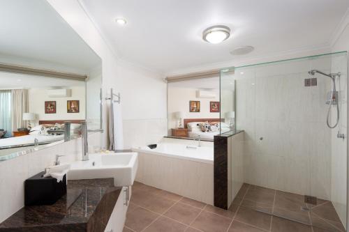 a bathroom with a tub and a sink and a shower at Luna Blu - Luxury B&B in Rhyll