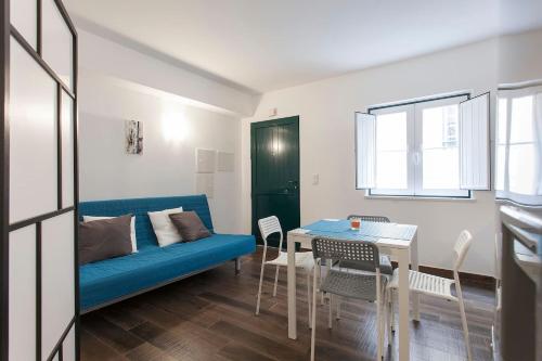 ein Wohnzimmer mit einem blauen Sofa und einem Tisch in der Unterkunft Studios of the Panteão, 0th floor in Lissabon