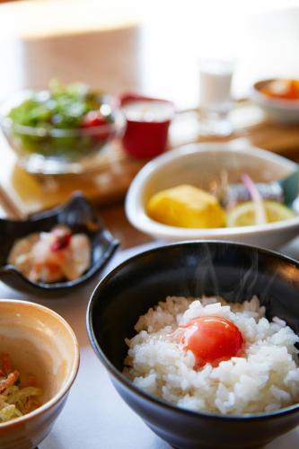 a table with a bowl of rice and other bowls of food at Yawaragi-no-Sato Yadoya in Yufuin