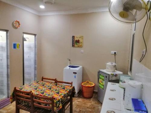 Zimmer mit einem Tisch, einem Bett und einem Ventilator in der Unterkunft KhainadzMuslim Homestay in Malakka