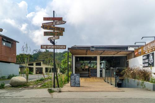a street sign with many signs in front of a store at OutBox Inn in Monteverde Costa Rica