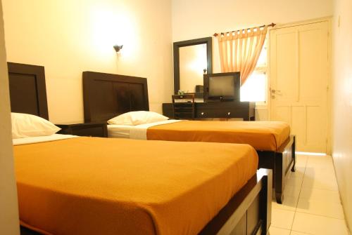 Tempat tidur dalam kamar di The Abidin Hotel Syari'ah