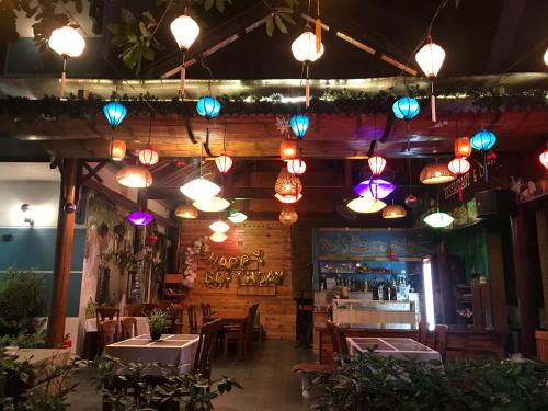 a restaurant with lights hanging from the ceiling at Lucky Leaf Hoian Villa in Hoi An