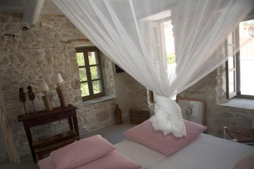 1 dormitorio con 1 cama con cortina blanca en Village House in Hora-Pythagorio, Samos Island en Chóra