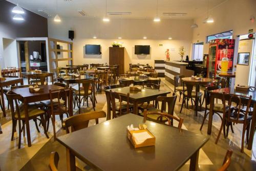 a restaurant with wooden tables and chairs and a room filled with tables at Apart Hotel Alegrete in Alegrete