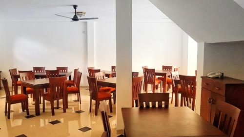 a dining room with wooden tables and chairs at Livinya Holiday Resort in Kataragama
