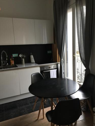 une cuisine avec une table et des chaises et une fenêtre dans l'établissement Charmant appartement hyper centre Comédie, à Montpellier