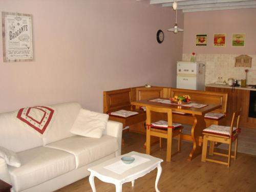 a living room with a white couch and a table at La Casetta dei Cuori in Averara