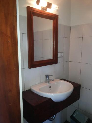 a bathroom with a sink and a mirror at Fishermen's Guesthouse in Amed