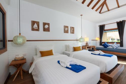 two beds in a room with white walls at Lanta Casa Blanca in Ko Lanta