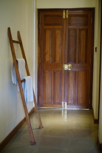 an empty room with a wooden door and a chair at Sevanagama in Habarana