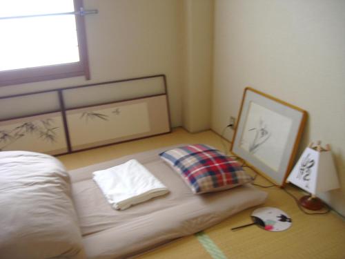 a bedroom with a bed with a pillow and a mirror at Special Honmachi in Okayama