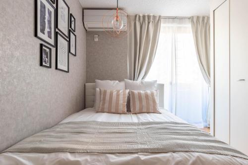 a bedroom with a large bed with a window at Exia Daikoku AFP Apartment in Osaka