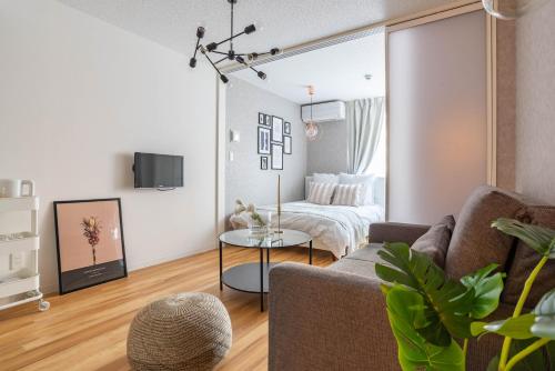 a living room with a couch and a table at Exia Daikoku AFP Apartment in Osaka