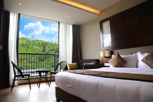 a hotel room with a bed and a large window at Casa Montana Munnar in Munnar