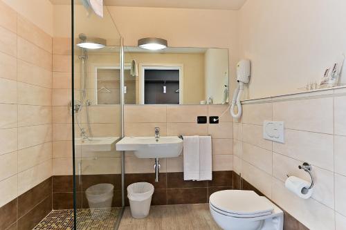 bagno con lavandino, servizi igienici e specchio di Rimmel Motel a Parma