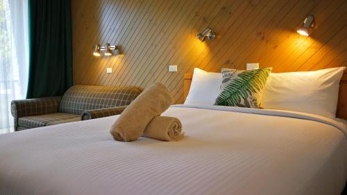 a hotel room with a bed with a stuffed animal on it at Banjo Paterson Motor Inn in Lakes Entrance