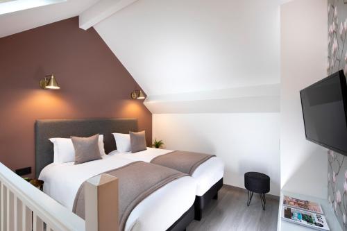 a bedroom with a bed and a flat screen tv at Hôtel Brady in Paris