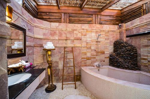 a bathroom with a bath tub and a ladder in it at Santhiya Koh Chang Resort in Ko Chang