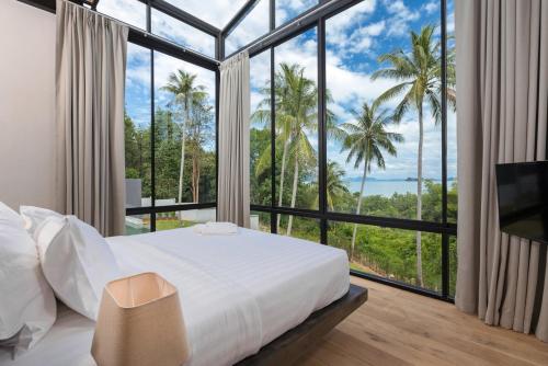 sypialnia z łóżkiem i dużym oknem w obiekcie Braya Villa w mieście Ko Yao Yai