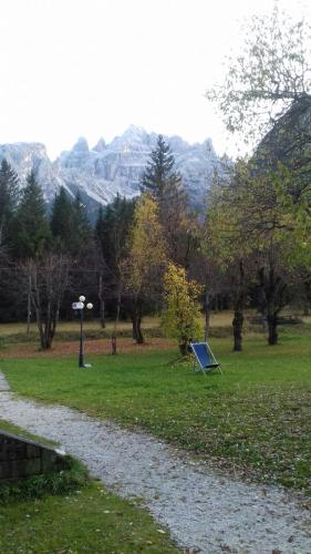 a park with a sign in the grass with mountains in the background at Ploner villaggio Turistico in Dobbiaco