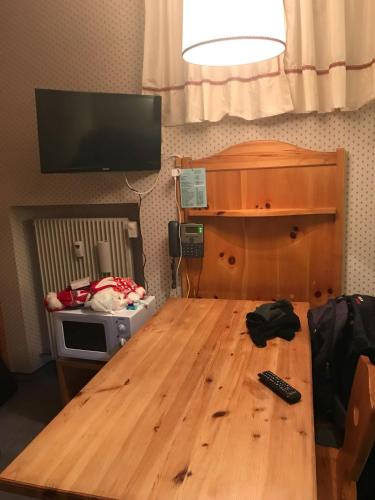 a wooden table with a remote control on top of it at Ploner villaggio Turistico in Dobbiaco