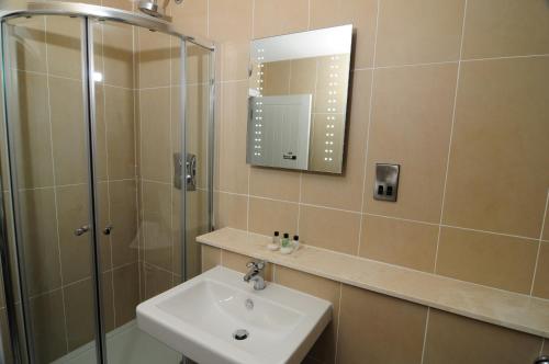a bathroom with a sink and a shower with a mirror at Station House - Room Only in Aberfeldy