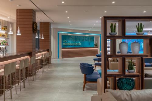 a restaurant with a bar with blue chairs at Mareblue Beach in Agios Spyridon Corfu