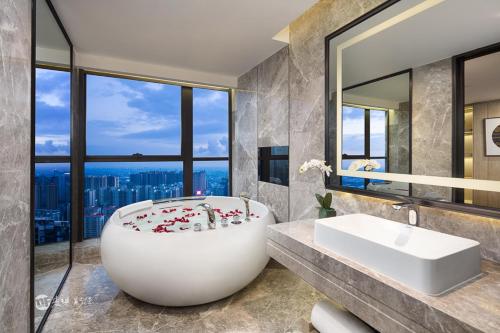 a bathroom with a large tub and a sink at Wyndham Grand Maoming in Maoming