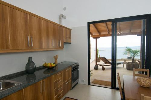 a kitchen with wooden cabinets and a view of the ocean at Residencial LaMar in Santa Cruz de la Palma