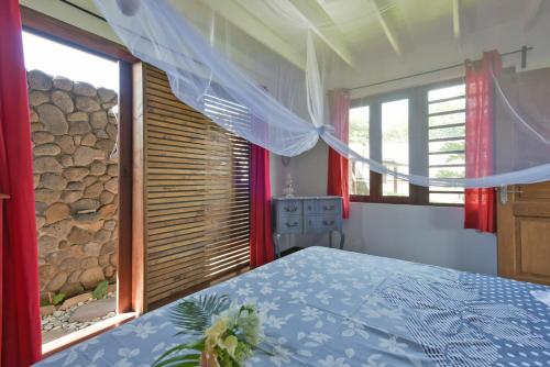a bedroom with a bed and a large window at Omati Lodge in Taravao