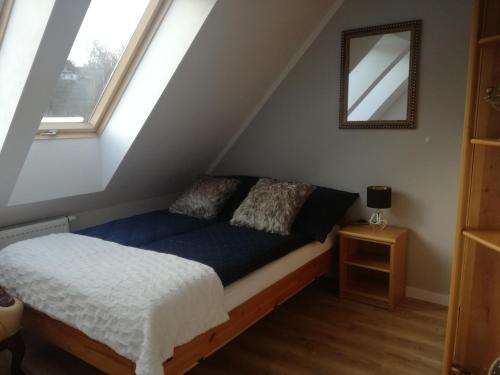 um quarto com uma cama num sótão em Apart Hotel 37 (108 m2) em Polanica-Zdrój