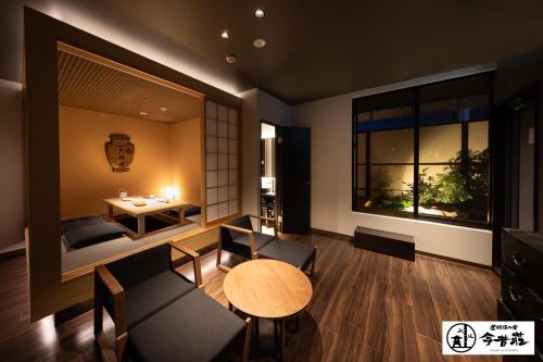 a room with a table and chairs and a room with a window at Konjaku-So Dotonbori Garden SPA Stay in Osaka