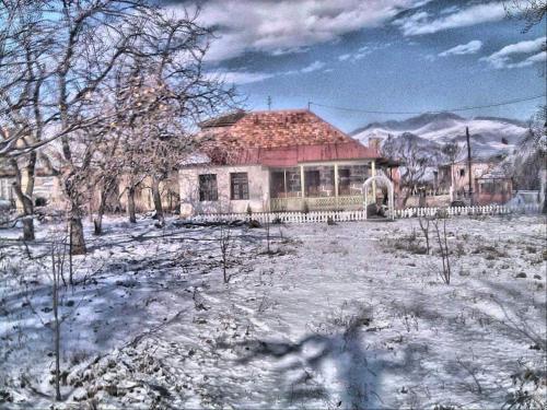 an old house with snow on the ground in front at Holiday Home Ruben in Odzun