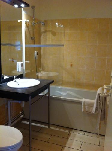 une salle de bain avec un lavabo, une douche et une baignoire dans l'établissement Hotel L'Océane Angers Parc Expo, à Saint-Sylvain-dʼAnjou