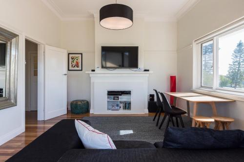 a living room with a couch and a table at Cottesloe Beach Deluxe Apartment in Perth