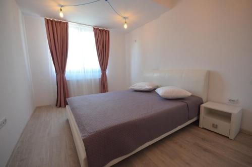 1 dormitorio con 1 cama con 2 almohadas y ventana en Rya Home, en Bucarest