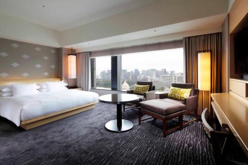 a hotel room with a bed and a large window at The Capitol Hotel Tokyu in Tokyo
