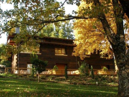 a large log house with a tree at Hotel Rural Las Rozuelas in Cercedilla
