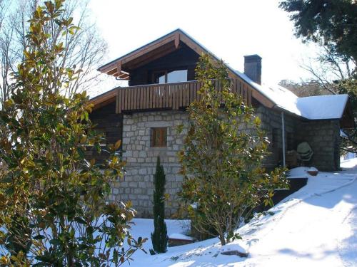 a house in the snow with trees in front of it at Hotel Rural Las Rozuelas in Cercedilla