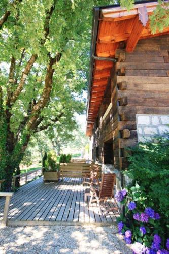 a wooden deck with two chairs and a building at Hotel Rural Las Rozuelas in Cercedilla