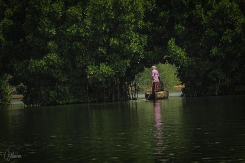 a person standing on a boat in a body of water at Munroe Eco Camp in Munroe Island