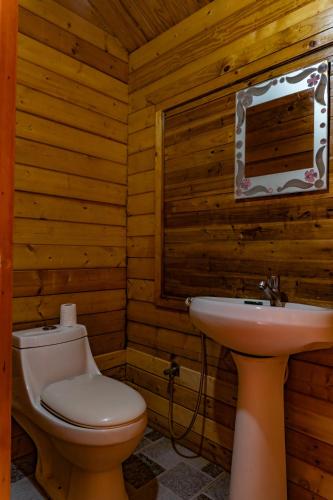 a wooden bathroom with a toilet and a sink at Vista Praia Beach Resort in Anjuna