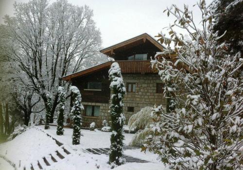a house covered in snow with trees in front of it at Hotel Rural Las Rozuelas in Cercedilla