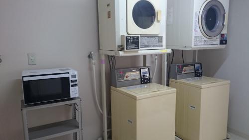 a room with three microwaves and three machines at Business Hotel Century in Nara