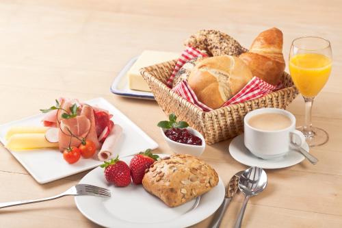 einen Tisch mit einem Korb Brot und einer Tasse Kaffee in der Unterkunft Dein Lieblingsplatz in Parey