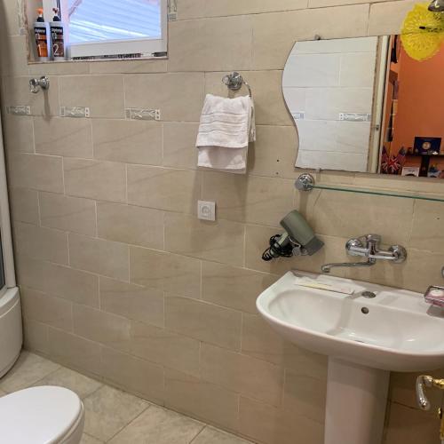 a bathroom with a sink and a mirror and a toilet at Your House In Tbilisi in Tbilisi City