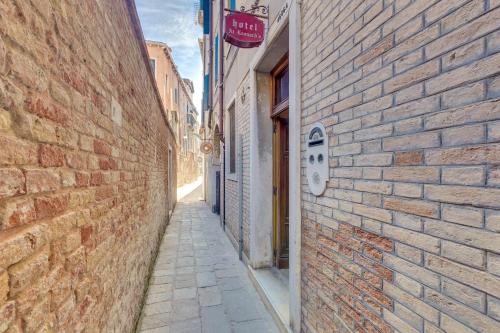 an alley in an old town with a brick wall at Hotel At Leonard in Venice